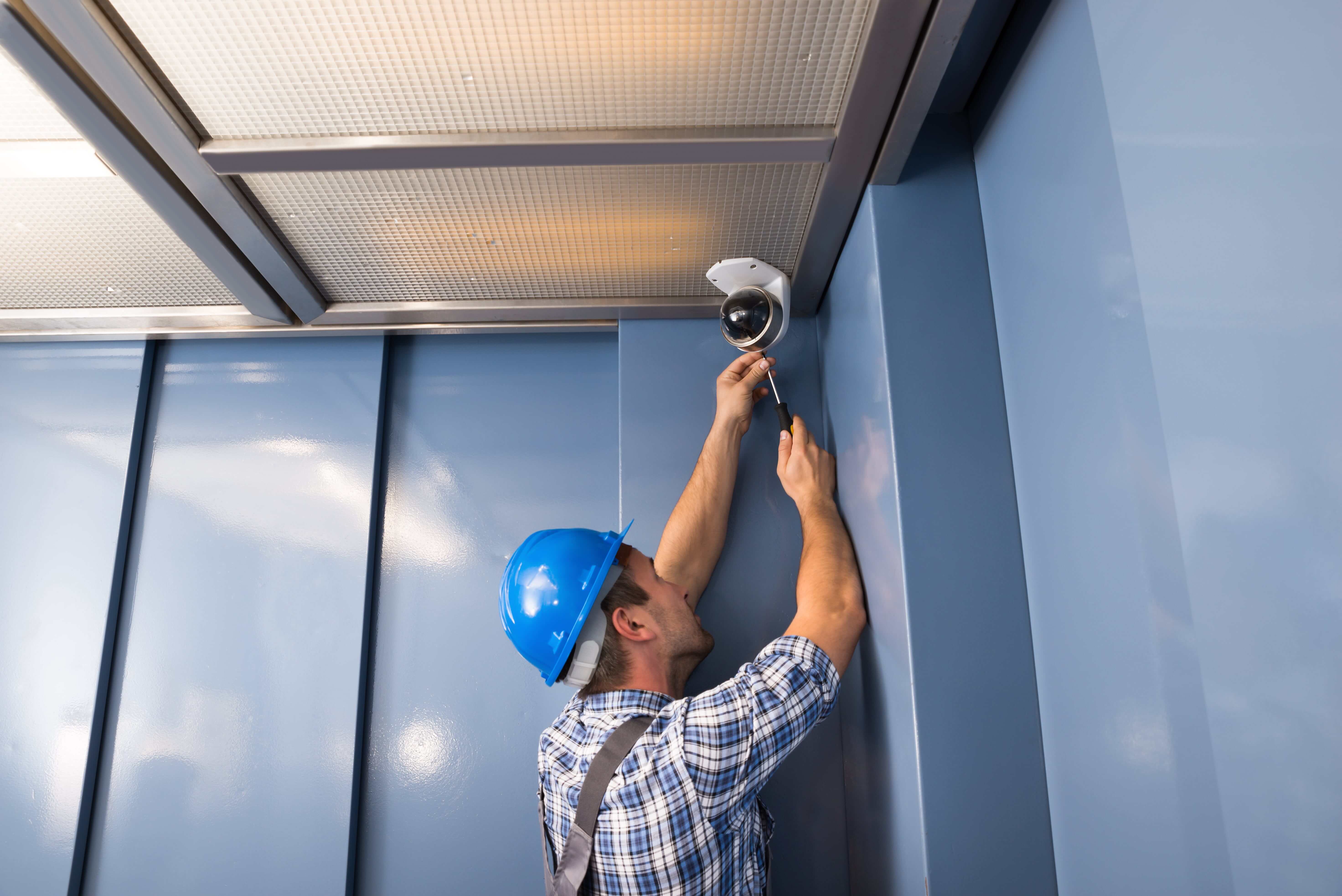 technician working on camera in elevator